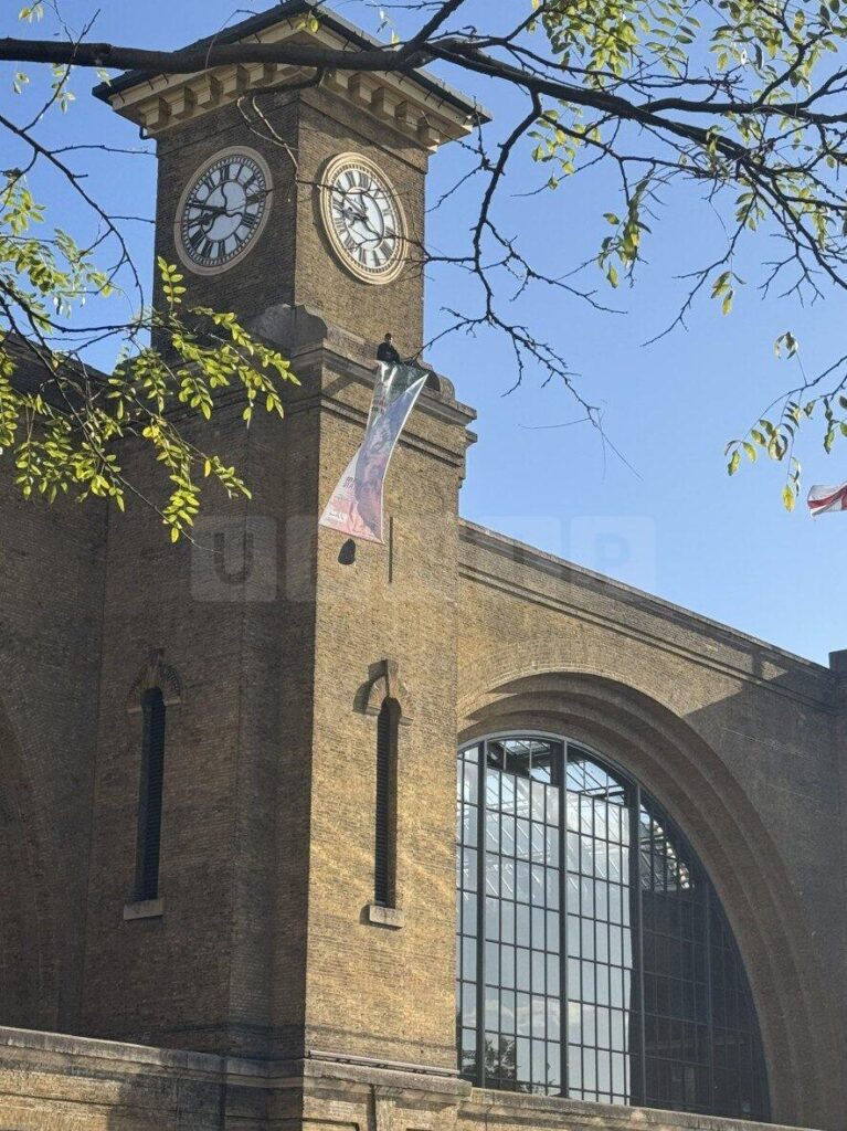 Protester and Pet Dog Scale King’s Cross Clock Tower in Anti-Iranian Government Demonstration