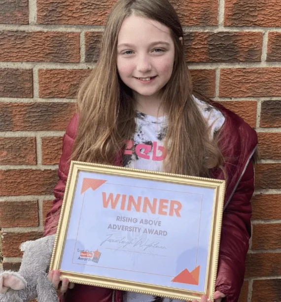A young girl who carried on caring for others when her life was being turned upside down has been given an award for her inspirational at