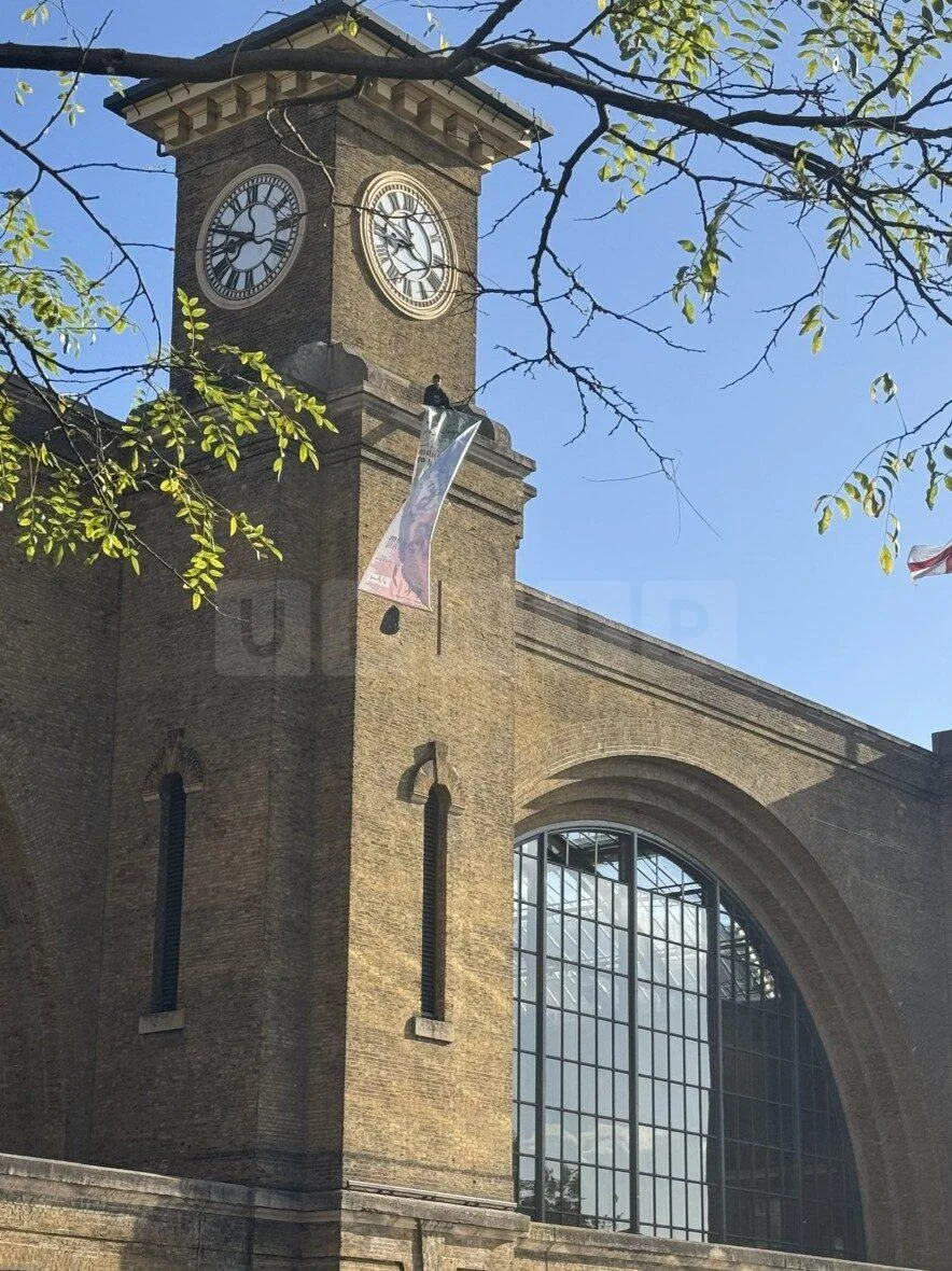 Protester and Pet Dog Scale King’s Cross Clock Tower in Anti-Iranian Government Demonstration