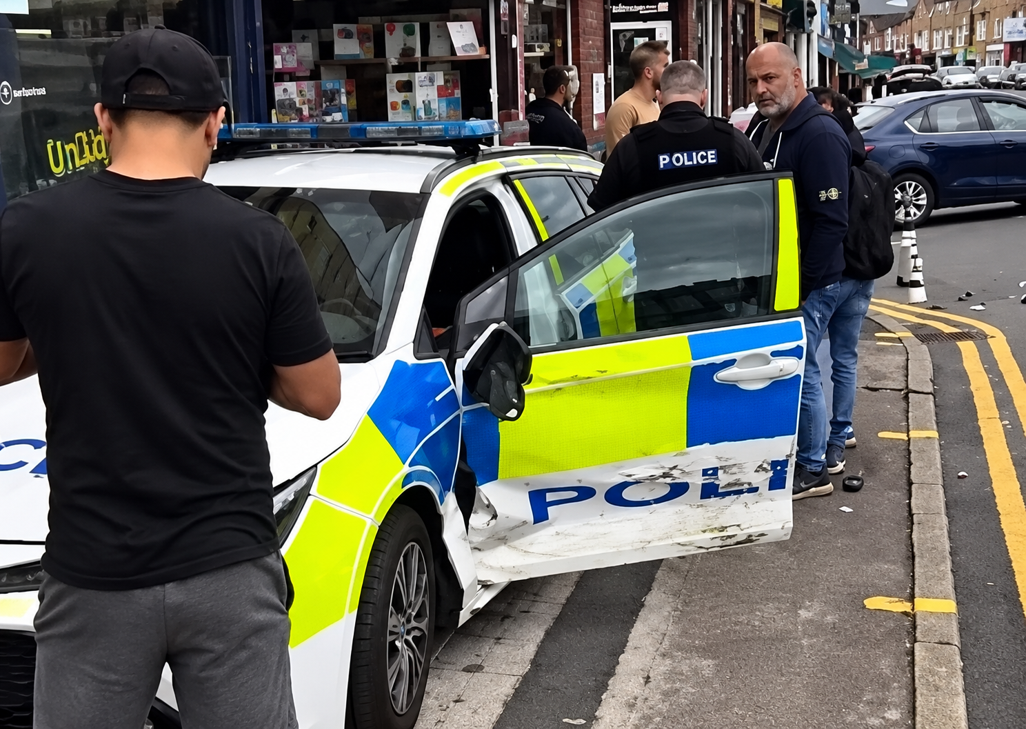 Police car crashes into Bolton shop while responding to emergency call